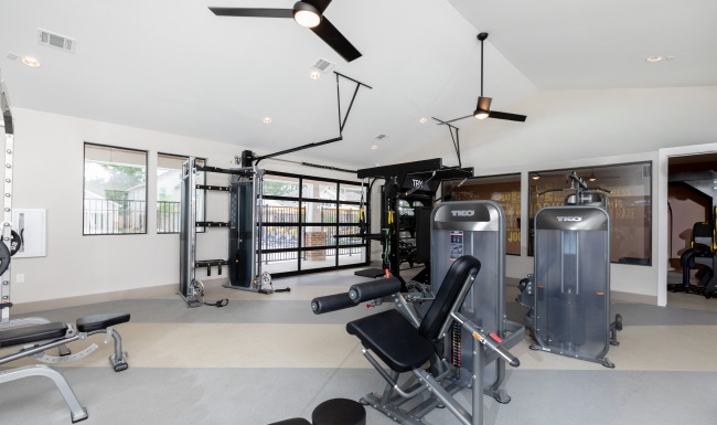 multiple pieces of fitness equipment with garage door in the back