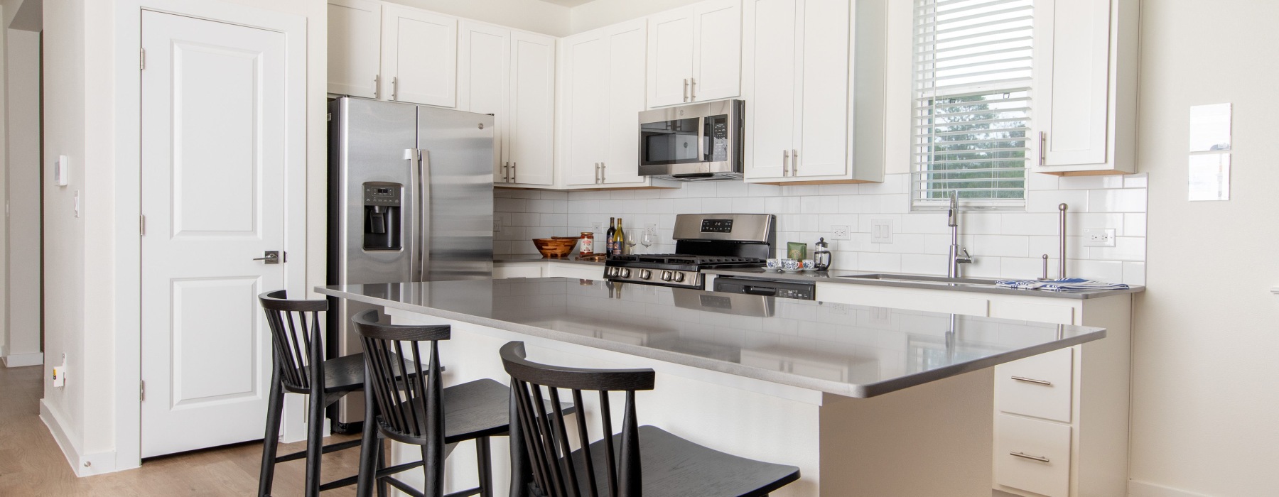 Kitchen with barstool chairs in the front 