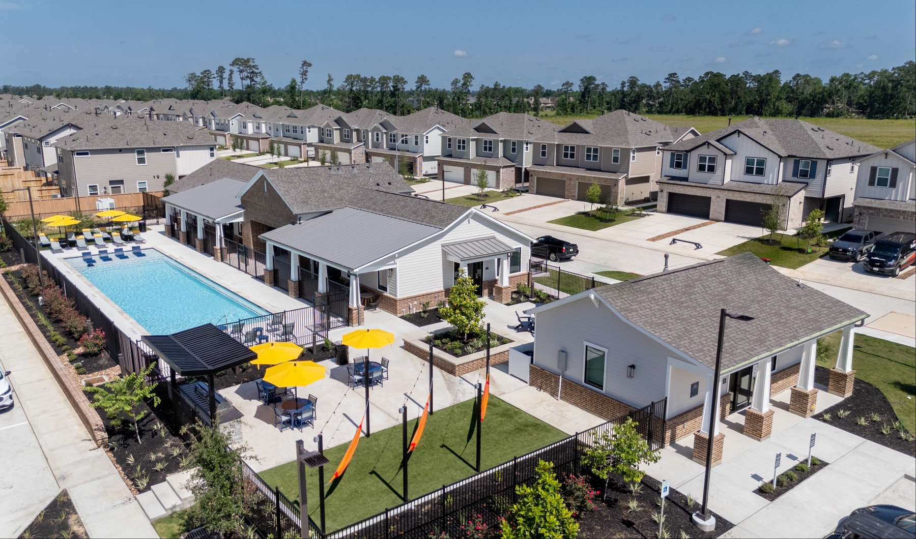 drone photo of Sycamore Heights' amenities with pool, hammocks, and houses in the background